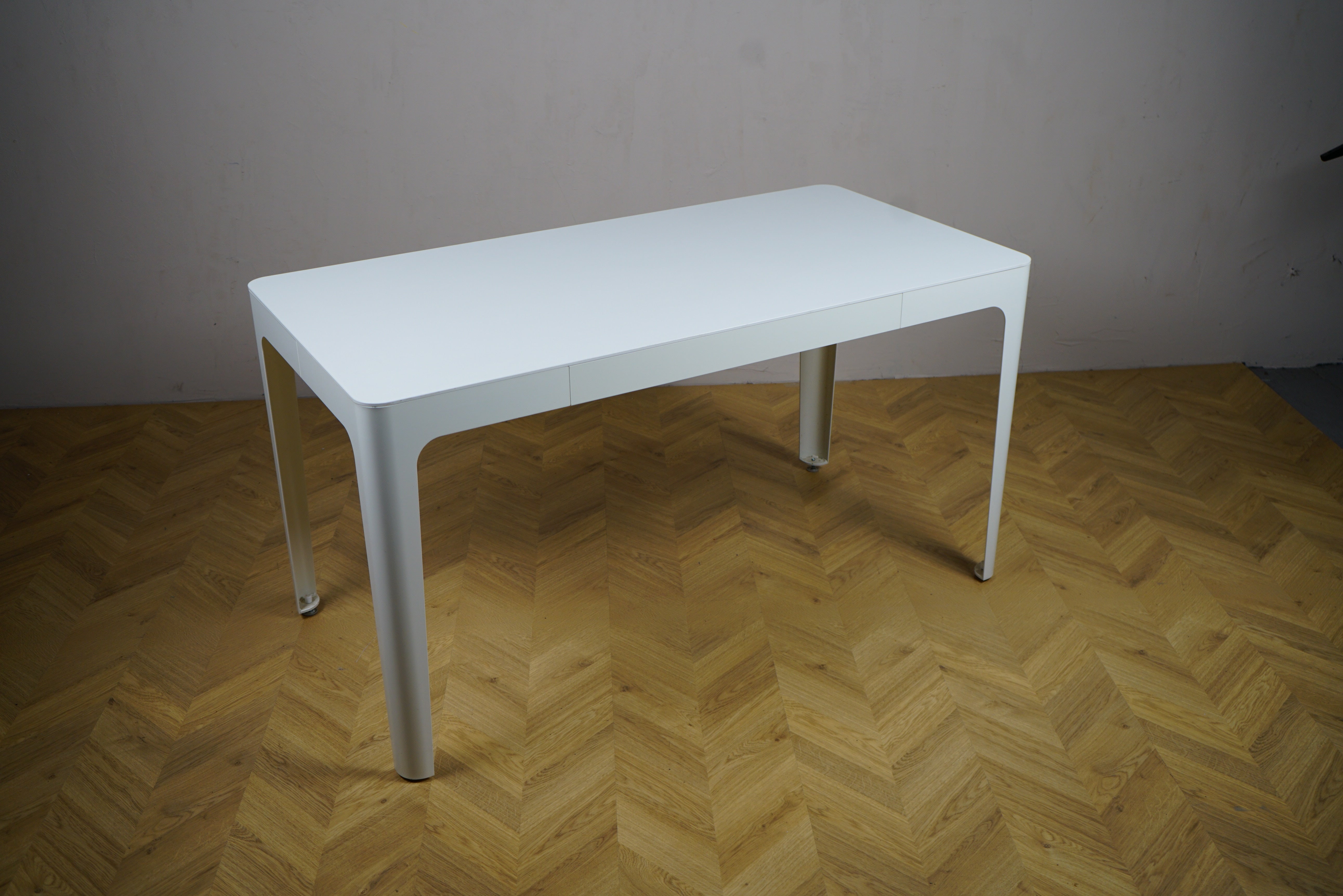 Kinnarps hvidt spisebord 140x70 cm i minimalistisk design set fra skrå vinkel – perfekt som møde-, lounge- eller kaffebord.